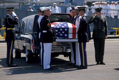 A joint services casket team removes the casket of the Unknown Serviceman of the Vietnam Era from a hearse at the beginning of the designation and departure ceremony. After the ceremony the Unknown Serviceman will be placed aboard the frigate USS BREWTON (FF 1086) for transport to Naval Air Station, Alameda, California