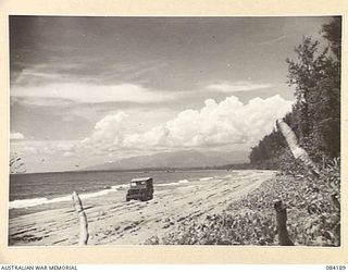 BOUGAINVILLE, SOLOMON ISLANDS. 1944-12-09. A 15 INFANTRY BATTALION JEEP TRAVERSING THE BEACH ROAD BETWEEN TAGESSI RIVER AND JABA RIVER, THE MAIN SUPPLY ROUTE TO THE BATTALION