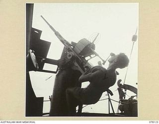 MADANG, NEW GUINEA. 1944-11-20. A MEMBER OF THE CREW OF THE ROYAL AUSTRALIAN NAVY VESSEL, HMAS "BENDIGO" MANNING ONE OF THE SHIPS OERLIKON GUNS