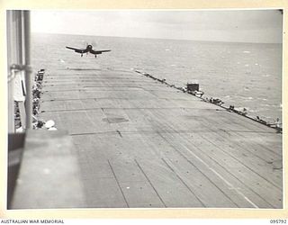 AT SEA OFF RABAUL, NEW BRITAIN. 1945-09-06. A CORSAIR AIRCRAFT COMING IN TO LAND ON THE FLIGHT DECK OF THE AIRCRAFT CARRIER HMS GLORY AFTER A COVERING PATROL OVERHEAD. CORSAIRS CIRCLED OVERHEAD ..