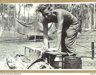 WONDECLA, 1943-10-06. NX105745 SIGNALLER E.J. DOOLAN OF THE 17TH AUSTRALIAN INFANTRY BRIGADE, SCRUBBING HIS CLOTHES OVER A BOARD IN PREPARATION FOR HIS TROPICAL LEAVE, AFTER HIS SERVICE IN NEW ..