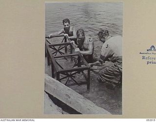 URFIP CREEK, WEWAK AREA, 1945-05-14. MEMBERS OF 2/8 FIELD COMPANY, ROYAL AUSTRALIAN ENGINEERS, PLACING A TEMPORARY PLATFORM FOR STRINGERS DURING THE CONSTRUCTION OF A BRIDGE OVER URFIP CREEK. ..