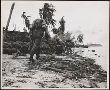 U.S. Marines invading Guam, hug the 'deck' on the beach