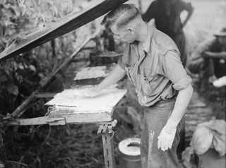 YAULA, NEW GUINEA. 1944-04-09. VX108667 SERGEANT J. BLOMLEY, 57/60TH INFANTRY BATTALION, PREPARES SCONES FOR BAKING USING AN OVEN IMPROVISED FROM ABANDONED JAPANESE PETROL DRUMS PACKED WITH EARTH