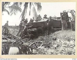 HANSA BAY AREA, NEW GUINEA. 1944-09-07. THIS CAPTURED JAPANESE TRUCK WHICH IS BEING USED FOR THE COURIER SERVICE FOR THE 25TH INFANTRY BATTALION BETWEEN THE BOROI RIVER AND POTSDAM HAS SLIPPED OFF ..