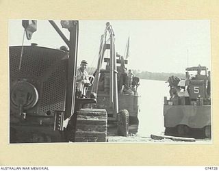 MADANG, NEW GUINEA. 1944. A LANDING BARGE BEING HAULED UP ON THE BEACH FOR REPAIR AT THE 593RD UNITED STATES BARGE COMPANY REPAIR WORKSHOPS