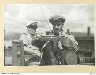 JACQUINOT BAY, NEW BRITAIN. 1944-11-08. FIRST LIEUTENANT N.E. MCDONALD, RAN, ON THE BRIDGE OF THE RAN FRIGATE BARCOO