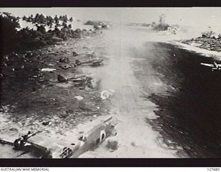 SAMATE, NEW GUINEA. JAPANESE AIRSTRIP ON SALAMATO ISLAND UNDER ATTACK BY MITCHELL B25 BOMBER AIRCRAFT OF FIFTH AIR FORCE, UNITED STATES ARMY AIR FORCE. BOMBS ARE BURSTING ON END OF RUNWAY WHILE ..