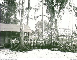 THE SOLOMON ISLANDS, 1945-10-13. JAPANESE NAVAL PERSONNEL LINE UP AT THEIR INTERNMENT CAMP ON MASAMASA ISLAND. (RNZAF OFFICIAL PHOTOGRAPH.)