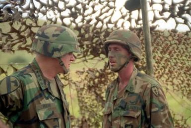 Army CHIEF of STAFF General (GEN) Carl E. Vuono speaks with a staff sergeant from the 25th Infantry Division (Light) during a visit to the training area