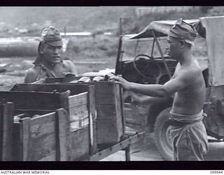 RABAUL, NEW BRITAIN, 1946-03-29. JAPANESE LABOURERS LOADING DIRTY BOTTLES ON A CONVEYER SYSTEM AT THE AUSTRALIAN ARMY CANTEENS SERVICE CORDIAL FACTORY. THE FACTORY, STAFFED BY SEVEN SKILLED ARMY ..