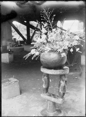 New Guinea flowers in a round bowl on a Trobriand Island stool,  Rabaul, New Guinea, ca. 1929 / Sarah Chinnery