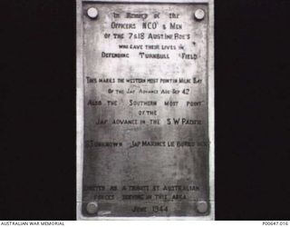 MILNE BAY, PAPUA, C.1944. PLAQUE ON THE CONCRETE MEMORIAL AT NO. 3 STRIP (TURNBULL FIELD). THIS MEMORIAL REPLACED AN EARLIER ONE (SEE P647/28/14) WHICH HAD BEEN REMOVED, PROBABLY SOUVENIRED. THE ..