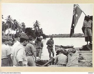 BONIS PENINSULA, BOUGAINVILLE. 1945-09-16. AUSTRALIAN FLAG FLYING AT THE STERN OF A 17 FIELD AMBULANCE BARGE. THE JAPANESE ARE LOADING SERIOUSLY ILL JAPANESE FOR TRANSFER TO 17 FIELD AMBULANCE, AT ..