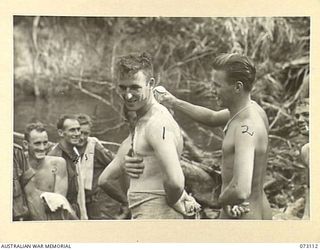 REMPI, NEW GUINEA. 1944-05-09. MEMBERS OF "A" COMPANY, 35TH INFANTRY BATTALION DUSTING WITH "TALC POWDER" AFTER AN ENJOYABLE SWIM IN A STREAM NEAR REMPI. THE TALCUM POWDER IS BEING USED TO PREVENT ..