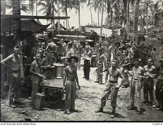 MOMOTE, LOS NEGROS ISLAND, ADMIRALTY ISLANDS. C. 1944-04. GROUND CREWS OF NO. 79 (SPITFIRE) SQUADRON RAAF LINE UP FOR LUNCH UNDER COCONUT PALM TREES