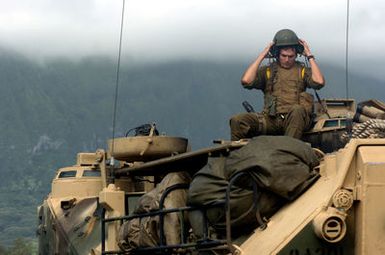 A US Marine Corps (USMC) Marine assigned to the 3rd Amphibious Assault Battalion sits atop his AAV7A1 Amphibious Assault Vehicle and removes his crew helmet, after a day of infantry training at Training Area Bellows, Hawaii (HI)