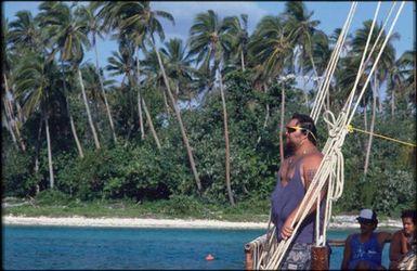 Man in blue singlet standing on boat