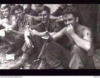 BUKAUA, NEW GUINEA. 1943-10-18. DINNER TIME FOR THE TROOPS OF THE 29/46TH AUSTRALIAN INFANTRY BATTALION AT THE LUTHERAN MISSION CHURCH. LEFT TO RIGHT: VX144382 PRIVATE (PTE) L. W. SMITH; VX144504 ..