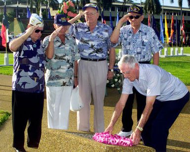 Veterans from the 11th Bomb Group, Hickam Air Force Base, Hawaii salute as Lieutenant Colonel Leslie Berton places a lay on a Dec 7, 1941 Memorial during the Pearl Harbor rememberance day ceremony