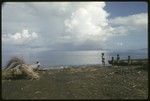 People at the coastline with shored canoes