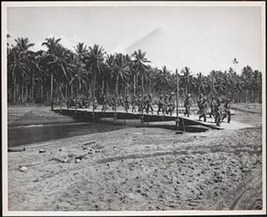 Moving across a bridge constructed by marine engineers on Guadalcanal