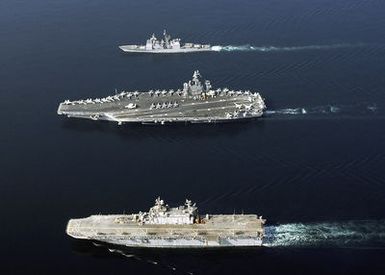 (From bottom-to-top), Aerial port view of the U.S. Navy Tarawa Class Amphibious Assault Ship USS SAIPAN (LHA 2), the Nimitz Class Aircraft Carrier USS DWIGHT D. EISENHOWER (CVN 69), and the Ticonderoga Class Guided Missile Cruiser USS ANZIO (CG 68), as they sail in formation during a photographic exercise on Nov. 20, 2006. The ships are currently deployed in support of maritime security operations in the Arabian Sea. (U.S. Navy photo by Mass Communication SPECIALIST SEAMAN Patrick W. Mullen III) (Released)