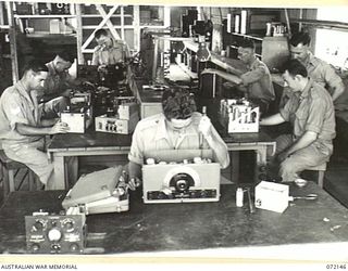 PORT MORESBY, NEW GUINEA. 1944-04-10. TECHNICIANS WORKING ON REPAIRS IN THE WIRELESS SECTION AT THE 11TH ADVANCED WORKSHOP, AUSTRALIAN ELECTRICAL AND MECHANICAL ENGINEERS