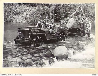 A jeep towing a tank attack gun over the ford constructed by engineers across the Hongorai River. The gun will be used by 57/60 infantry battalion to clean out Japanese positions on the escarpment ..