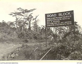 FINSCHHAFEN AREA, NEW GUINEA, 1944-03-17. ONE OF THE MANY BATTLE SIGNS IN THE AREA, THIS ROAD BLOCK SIGN RECORDS THE ACTIVITIES OF THE 2/13TH INFANTRY BATTALION AND "A" COMPANY, 2/17TH INFANTRY ..
