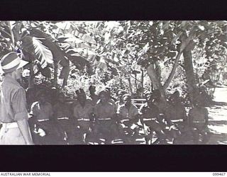 RABAUL, NEW BRITAIN, 1945-12-17. SERGEANT J. MORRIS, AUSTRALIAN ARMY EDUCATION SERVICE CONDUCTING A MUSIC CLASS AT 1ST NEW GUINEA INFANTRY BATTALION