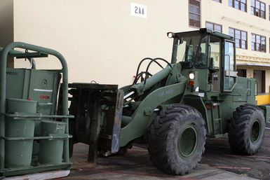 US Marine Corps (USMC) Sergeant (SGT) Wills, assigned to Combat Service Support Group 3 (CSSG-3), Marine Forces Pacific (MARFORPAC) uses a Rough Terrain Forklift to upload a Combat Camera and Printing (CC&P) air conditioning unit onto a transport truck at Camp H.M. Smith, Hawaii (HI), as the Unit prepares for deployment to Iraq, in support of Operation IRAQI FREEDOM