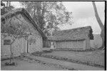 Edwin Cook's house in Kwiop: house and kitchen structure, employee stands between