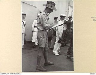 AT SEA OFF RABAUL, NEW BRITAIN. 1945-09-06. CAPTAIN DENNIS ADAMS, OFFICIAL WAR ARTIST, SKETCHING THE SURRENDER CEREMONY TAKING PLACE ON BOARD THE AIRCRAFT CARRIER HMS GLORY. THE SURRENDER OF ALL ..