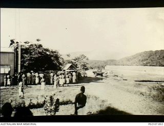 Salamaua, New Guinea. 1941-12. A crowd of people stand outside the airport hangar as women and children are evacuated from Salamaua, following the Japanese raid on Pearl Harbour. The women and ..