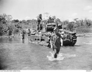 BOUGAINVILLE, 1945-05-16. A MATILDA TANK OF B SQUADRON 2/4 ARMOURED REGIMENT, SUPPORTED BY INFANTRY CROSSING THE HONGORAI RIVER DURING THE 24 INFANTRY BATTALION ADVANCE SOUTH ALONG THE BUIN ROAD. ..