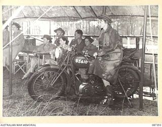 HERBERTON, QUEENSLAND. 1945-03-03. SISTER B.D. BACKHOUSE, 2/6 GENERAL HOSPITAL, (3), AMONG OTHER AUSTRALIAN ARMY NURSING SERVICE MEMBERS WATCHING A MARCH PAST OF UNITS DURING A PARADE AT HERBERTON ..