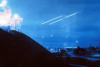 Missile re-entries mark the sky with streaks of light above a station