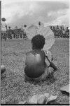 Mortuary ceremony: child watching exchanges uses large leaf for shade