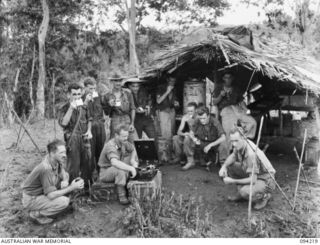 ULEBILUM, NEW GUINEA. 1945-07-13. CAPTAIN TAIT, SALVATION ARMY RED SHIELD OFFICER IN CHARGE OF THE AUSTRALIAN COMFORTS FUND COFFEE STAFF, PROVIDING MUSIC WITH COFFEE. EACH NIGHT AFTER MESS PARADE ..