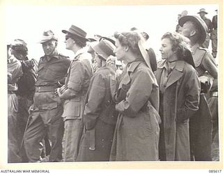 HERBERTON RACECOURSE, WONDECLA, ATHERTON TABLELAND, QLD. 1945-01-19. WOMEN SPECTATORS AT HQ 9 DIVISION WATCHING THE BAND CONTEST DURING THE 9 DIVISION GYMKHANA