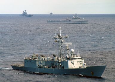 US Navy (USN) and Spanish Navy ship maneuver through the waters of the Atlantic Ocean while participating in the North Atlantic Treaty Organization (NATO) Exercise Standing Naval Force Atlantic (SNFL). The Standing Naval Force is a squadron of eight to ten destroyers and frigates from different nations in the NATO organization. Pictured foreground-to-background: The Spanish Navy, Santa Maria Class Frigate, NAVARRA (F 85); the USN Austin Class Amphibious Transport Docks, USS TRENTON (LPD 14); the USN Tarawa Class Amphibious Assault Ship, USS SAIPAN (LHA 2), and the USN Oliver Hazard Perry Class Frigate, USS SIMPSON (FFG 56)