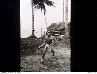 Madang, New Guinea, 1945-07. Flight Lieutenant Jim Hodges plays a game of 'batington' at Headquarters, RAAF Northern Command (NORCOM), on the shores of Astrolabe Bay. The game is a local variant of ..