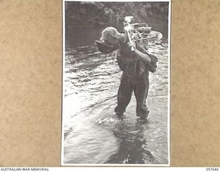 MARINGGUSIN, NEW GUINEA, 1943-09-29. VX116662 PRIVATE G. ALLEN, "A" COMPANY, 2/14TH AUSTRALIAN INFANTRY BATTALION, DRINKING WATER FROM HIS STEEL HELMET WHILE CROSSING THE YATI RIVER, DURING THE ..