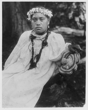 Unidentified woman leaning on a branch at Mauke, Cook Islands