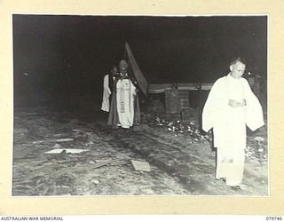 TOROKINA, BOUGAINVILLE, SOLOMON ISLANDS. 1945-03-14. CHAPLAIN P.N.W. STRONG, ANGLICAN BISHOP OF NEW GUINEA (1) AND ACCOMPANYING CLERGY APPROACHING THE ENTRANCE TO THE 2/1ST GENERAL HOSPITAL TO ..
