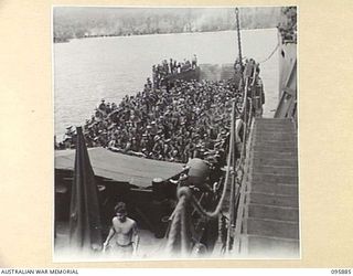 WEWAK HARBOUR, NEW GUINEA. 1945-09-03. BARGES CONTAINING AUSTRALIAN TROOPS COMING ALONGSIDE THE TROOPSHIP, SS RIVER FITZROY. THIS IS THE FIRST TIME AN AUSTRALIAN FREIGHTER HAS BEEN CONVERTED INTO A ..