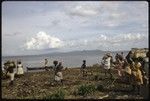 People on beach taking goods to a boat