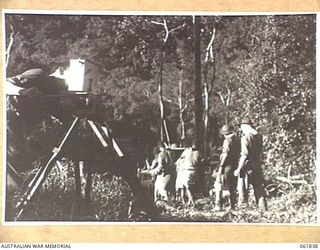 UBERI, NEW GUINEA. 1943-12-19. MR GEORGE HEATH (1) CHIEF CAMERAMAN OF CHAUVEL'S PRODUCTIONS FILMING TROOPS OF THE 2/9TH AUSTRALIAN INFANTRY BATTALION, WHO ARE PLAYING THE PART OF WALKING WOUNDED ..