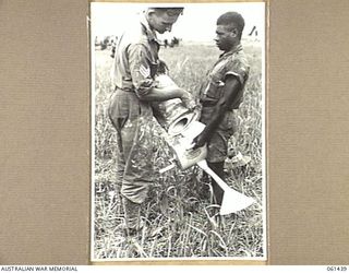 DUMPU, NEW GUINEA. 1943-12-06. QX44074 SERGEANT A. F. SMITH OF THE 18TH AUSTRALIAN ANTI-MALARIAL CONTROL UNIT FILLING A ROTARY BLOWER WITH DDT POWDER. THIS DRY POWDER IS SUBSTITUTED FOR OIL ON ..